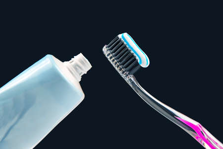 toothbrush with toothpaste for cleaning teeth on a dark background. health care. health items