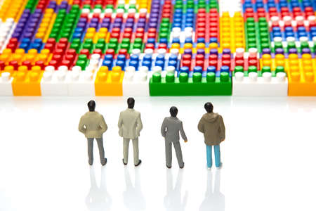 miniature people. figures of people stand near the colored plastic blocks of the designer. concept...