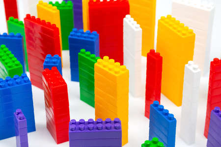 colored blocks of a plastic constructor on a white background in the form of multi-storey buildings. concept of modern buildings and housesの写真素材