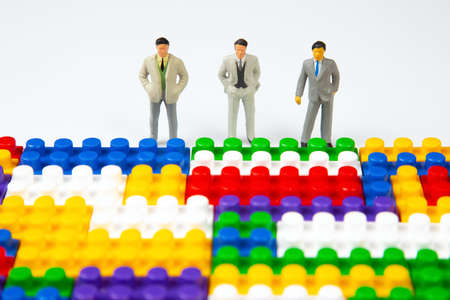 miniature people. figures of people stand near the colored plastic blocks of the designer. concept of business and industrial development. the concept of dreams and choice of life directionの写真素材