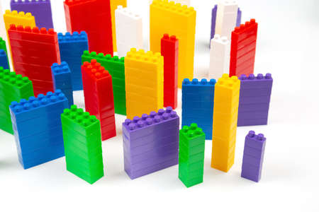 colored blocks of a plastic constructor on a white background in the form of multi-storey buildings....