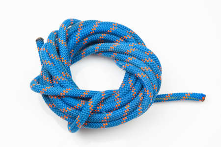 durable colored rope for climbing equipment on a white background. coil of braided cable. item for...