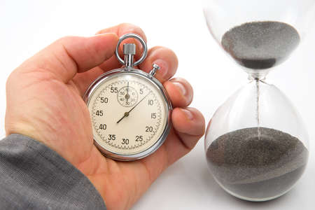 mechanical stopwatch and hourglass in hand. Time part precision. Measuring the speed interval with a...