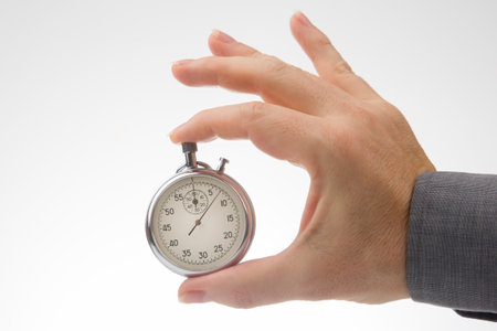 hand with a mechanical analog stopwatch on a white background. Time part precision. Measurement of the speed intervalの写真素材