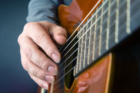 man plays the classical guitar. string musical instrument. hands of the musician playing on...
