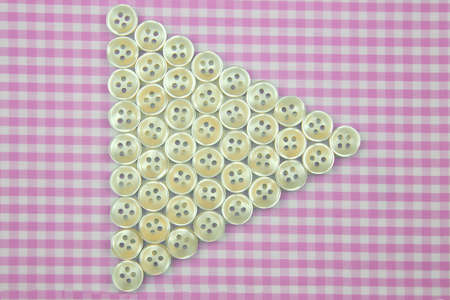 Plastic shiny buttons for clothes on a fabric background. fashion and clothing. factory industryの写真素材
