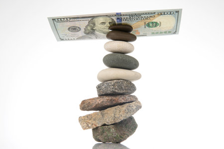 dollars on a pyramid of smooth stones. concept of balance and business success in life.