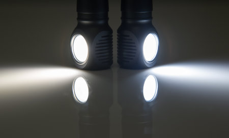included light beams of different flashlights on a dark background. comparison of light temperature. camping and household item.の写真素材
