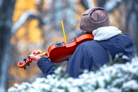 Street musician playing the violin. Musical creativity. Bowed stringed musical instrumentの写真素材