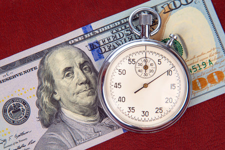 mechanical stopwatch on the background of dollars. Part time accuracy for business. business and finance time.の写真素材