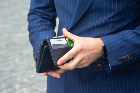 businessman in a suit opens his business leather wallet close upの写真素材