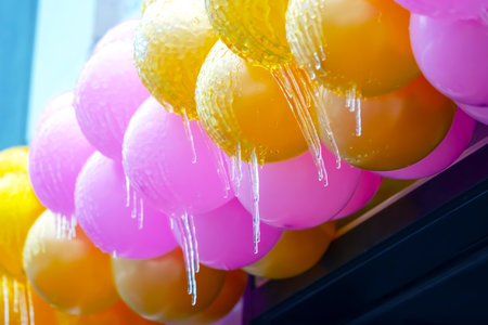 icicles on frozen colored inflatable holiday balls. winter weather season. street interior detailsの写真素材