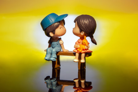 miniature people. figures for the game. romantic couple of young people. boy and girl sitting on a benchの写真素材