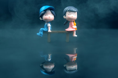 miniature people. figures for the game. romantic couple of young people. boy and girl sitting on a benchの写真素材