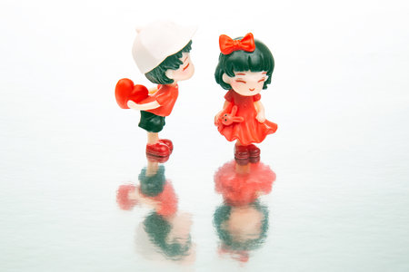 miniature people. figures for the game. romantic couple of young people. A boy lovingly gives his heart to a cute girlの写真素材