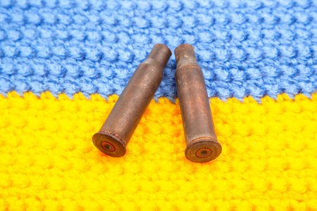 used cartridge cases from a machine gun cartridge against the background of the Ukrainian flag. war...