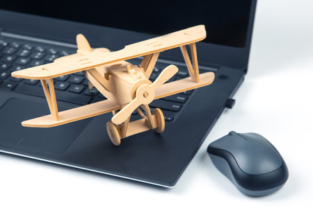 Model of a wooden plane on the background of a laptop. business development and success. Dream to fly in your favorite business.の写真素材