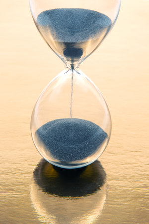 hour glass on a golden background. time and minute measurementsの写真素材