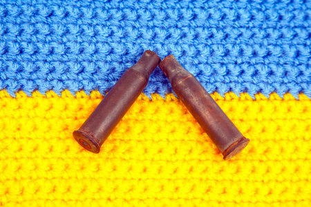 used cartridge cases from a machine gun cartridge against the background of the Ukrainian flag. war...
