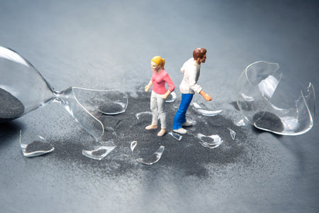 miniature people. a couple of people near a broken hourglass. crisis of personal relationships....