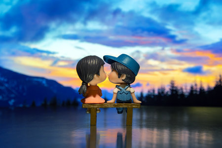 miniature people. figures for the game. romantic couple of young people. boy and girl sitting on a benchの写真素材