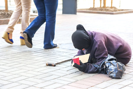 homeless beggar woman begs for alms on the city streetの写真素材