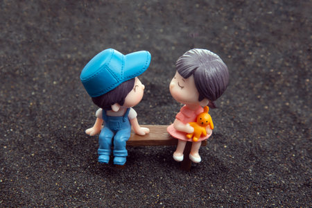 miniature people. figures for the game. romantic couple of young people. boy and girl sitting on a benchの写真素材