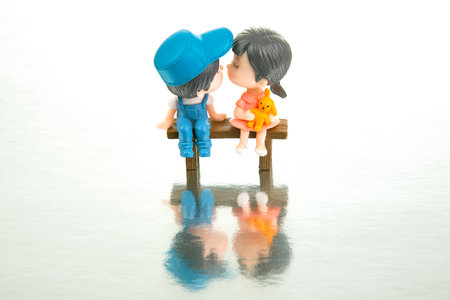 miniature people. figures for the game. romantic couple of young people. boy and girl sitting on a...