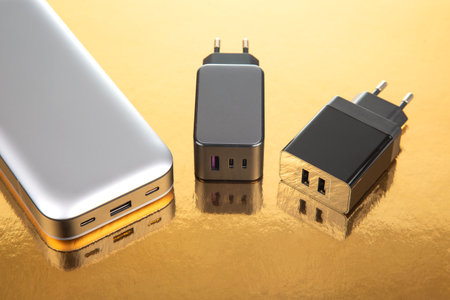 Power bank and charging plug on a golden background. Electronic devices for charging gadgets