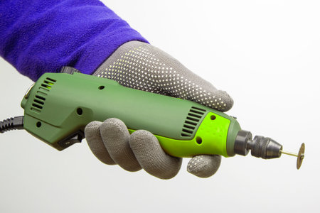 Engraving tool for cutting and processing metal and other objects in hand on a white background. locksmith industryの写真素材