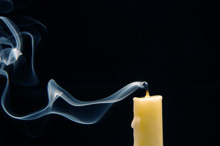 Smoke from an extinguished candle on a dark background. The concept of spirituality and the end of life.の写真素材
