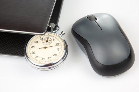Stopwatch and laptop with a mouse on a white background. Time control for work and games onlineの写真素材