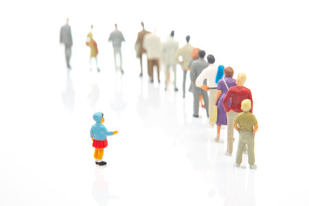 miniature people. little girl stands against the background of other people on a white background. Loneliness and family acceptance in human society. childcareの写真素材