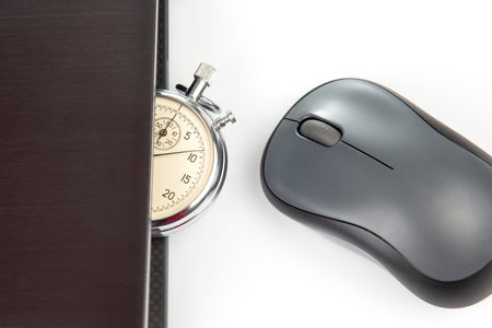Stopwatch and laptop with a mouse on a white background. Time control for work and games onlineの写真素材