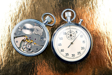 mechanical analog stopwatch on a colored background. Time part precision. Measurement of the speed...