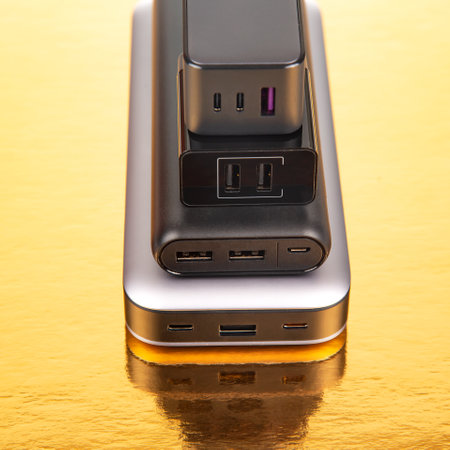 Power bank and charging plug on a golden background. Electronic devices for charging gadgetsの写真素材