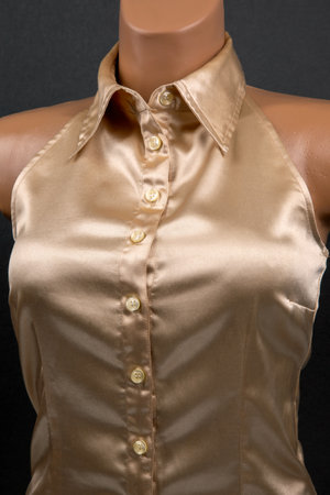 Satin and silk women shirt with mother-of-pearl buttons on a dark background. Style and fashion in clothes. Textile industry.の写真素材
