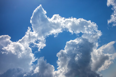 White clouds in the blue sky against the bright sun