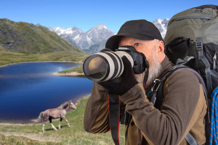 bearded man tourist photographer with a backpack photographs the beauty of nature in the mountains. nature hikes in the mountainsの写真素材
