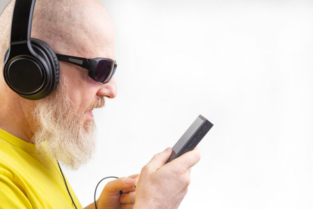 bearded man in sunglasses and headphones listens to music. audio sound style and technologyの写真素材
