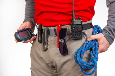 walkie-talkie, flashlight, knife, GPS navigator, climbing rope on the belt of the tourist trekking...