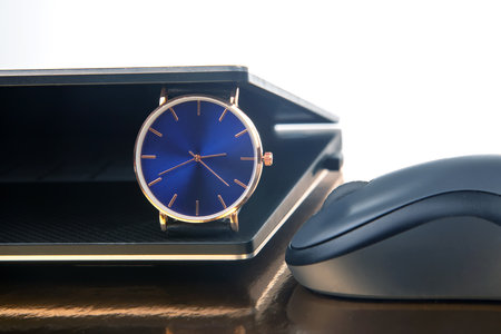 Clock and laptop with mouse. Time control for work and games online. Duration of work with a laptop
