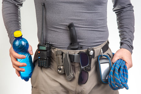 water, sunglasses, walkie-talkie, flashlight, knife, GPS navigator, climbing rope on the belt of the...