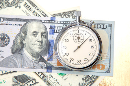 mechanical stopwatch on the background of dollars. Part time accuracy for business. business and finance time.の写真素材