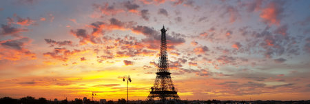 Stunning silhouette of the Tower against a vibrant sunset sky with orange, pink, and purple hues. Scattered clouds enhance the dramatic landscape, perfect for travel and romantic themes.の写真素材