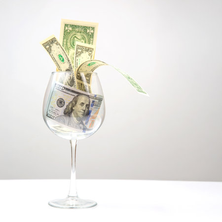 dollar banknotes money lies in an empty wine glass.の写真素材