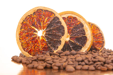 colorful dried orange slices with a rustic charm, complemented by a bed of coffee beans. Against a white background, ideal for health food, coffee culture, or artistic displays.の写真素材