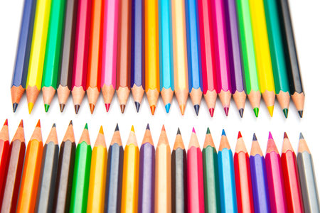 A close-up of vibrant colored pencils arranged in rows on a white background. Perfect for promoting art materials, back-to-school, or creative inspiration.の写真素材