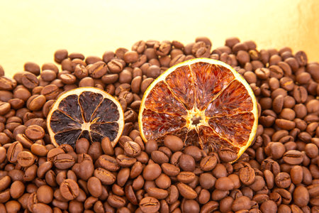 A vibrant close-up of dried orange slices nestled among roasted coffee beans, creating a warm, aromatic fusion of citrus and coffee textures. coffee aroma and taste descriptorsの写真素材