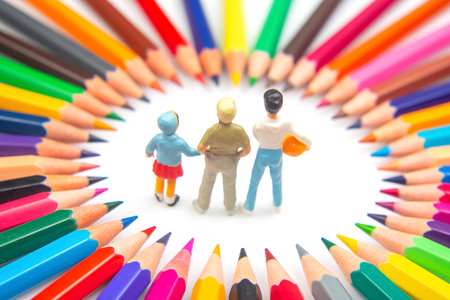 Three figurines are encircled by a spectrum of colored pencils, arranged in a starburst pattern,...